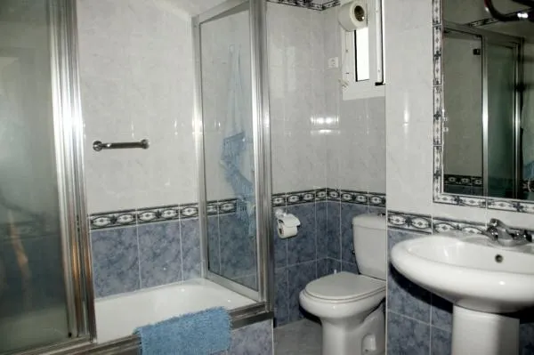 Cuarto de baño. Bañera con ducha, bidé, lavabo, inodoro, Gel, Champú, papel higiénico, secador de pelo, y toallas.